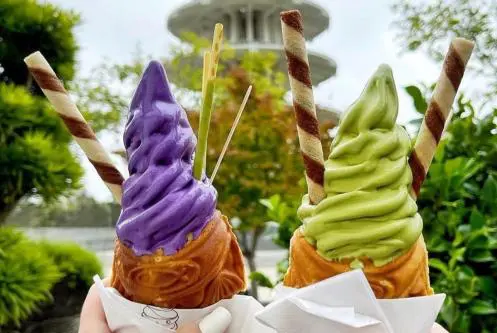 Two cones of ice cream with a straw in them.